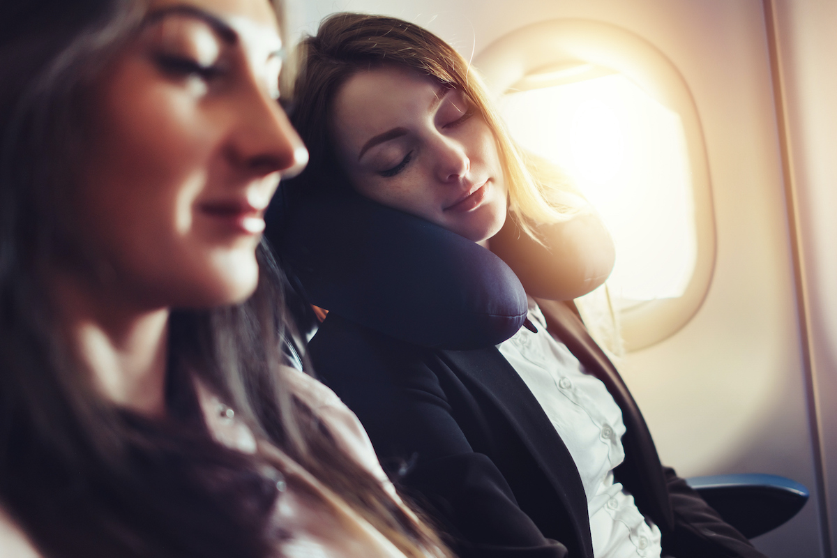 friends traveling by air sleeping on plane