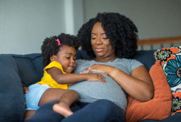 pregnant BIPOC mother and daughter
