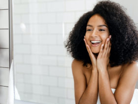 happy BIPOC woman admiring skin