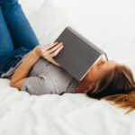 relaxed woman on bed with book