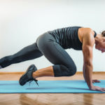 woman on yoga mat doing HIIT workout at home