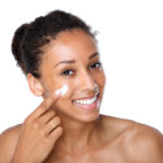 BIPOC woman applying skincare