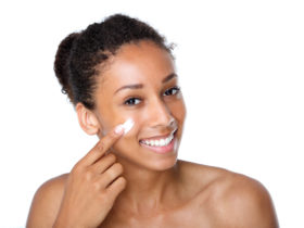 BIPOC woman applying skincare