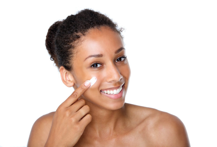 BIPOC woman applying skincare