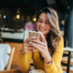 happy woman looking at smartphone