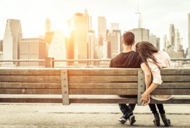man and woman snuggling on a bench