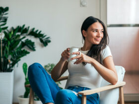 Beautiful young woman drinking coffee. Can adding this 1 spice to your coffee or tea help manage symptoms of PCOS?