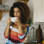 Beautiful young woman enjoying a cup of energizing caffeine free tea