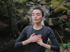 Young woman practicing breathing yoga pranayama outdoors in moss forest