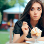 Young woman emotional eating ice cream