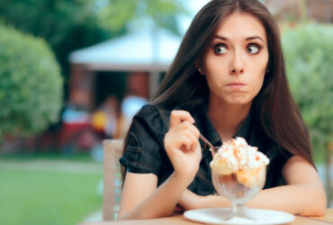 Young woman emotional eating ice cream