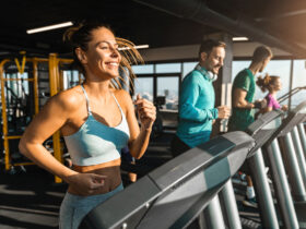 Happy athletic people jogging on treadmills in a health club
