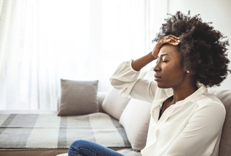 Stressed Black woman holds her hand to her face. Discover the link between stress and mental health.