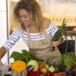 Smiling woman in the kitchen prepping food for Instant Pot recipes.