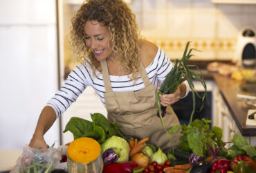 Smiling woman in the kitchen prepping food for Instant Pot recipes.