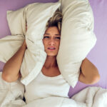 woman in her 40s lying in bed desperate about what causes night sweats. Find out what nobody tells you about night sweats.