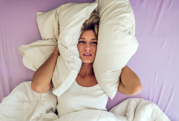 woman in her 40s lying in bed desperate about what causes night sweats. Find out what nobody tells you about night sweats.